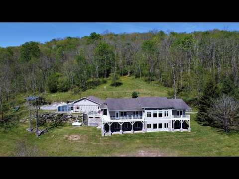 Aerial and interior video tour of a seven bedroom home on 100 acres of meadows, woods, and trails with majestic views in Marlinton, West Virginia, listed for $1.25 million.