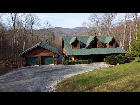 Exterior and interior video tour of a five bedroom, 3,232 square foot log home on 15 acres near Snowshoe Resort, rental ready with everything conveying, listed for $800,000.
