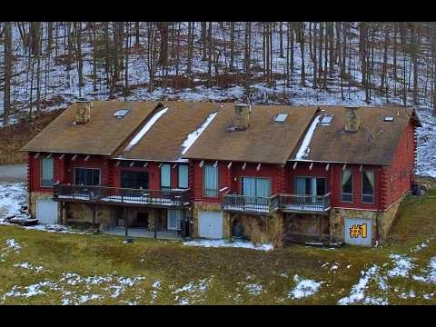 Exterior and interior video tour of a three bedroom plus loft, two bath, 1,862 square foot log townhome at Snowshoe Resort, furnished with no HOA fees, listed for $339,900.